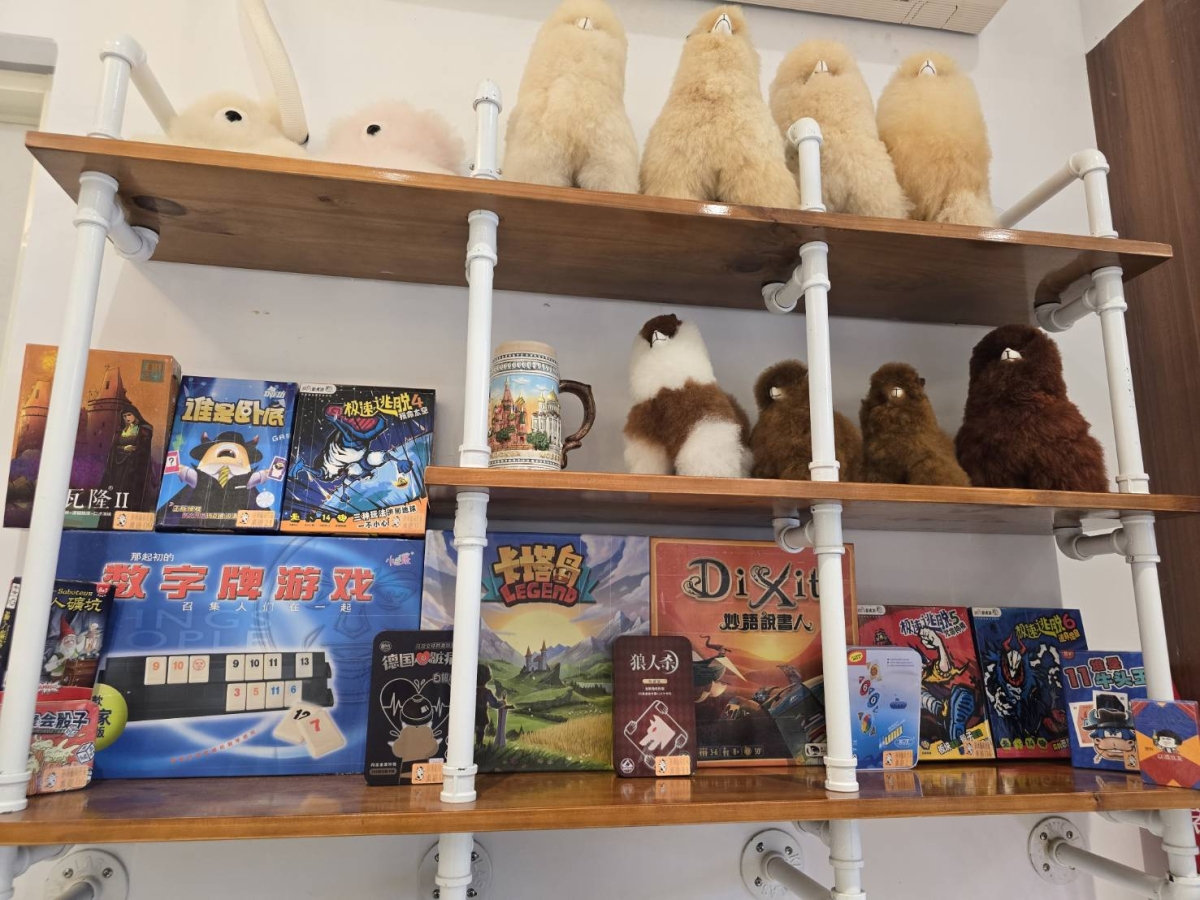 旅境桌遊展示架全景,可見多款實際桌遊盒與玩偶。
